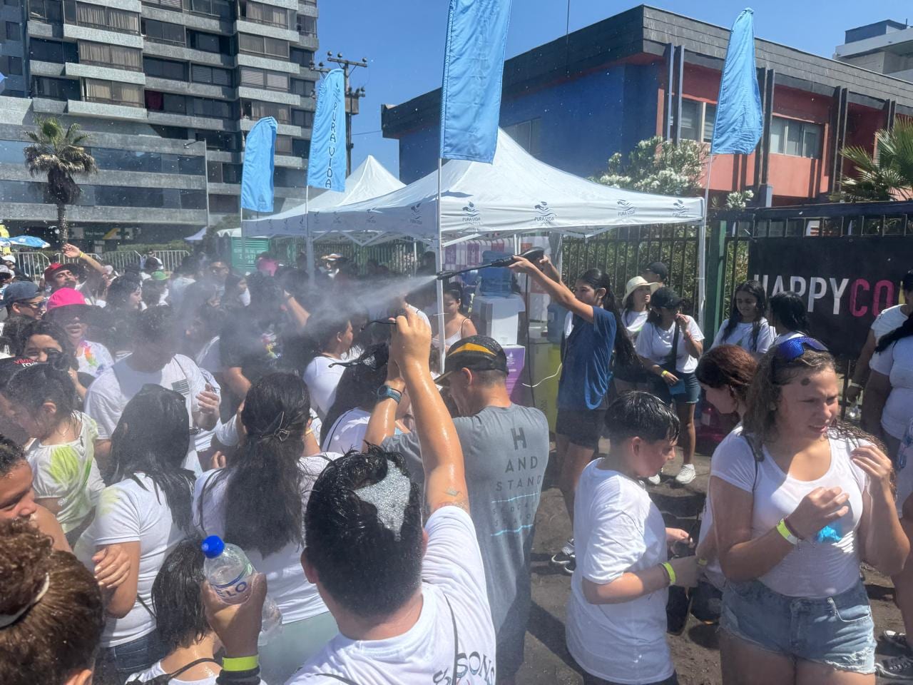 Estación de agua Pura Vida refrescando a participantes en una carrera de color